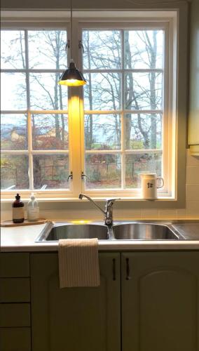 a kitchen with a sink and a window at Historic villa with large garden in Stord