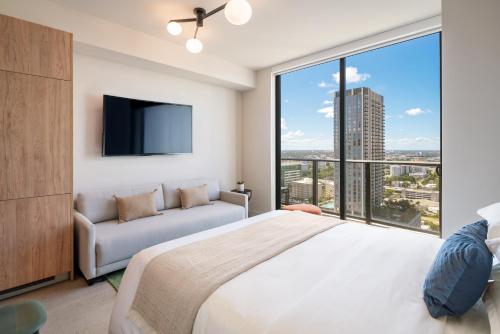 a bedroom with a large bed and a large window at The Crosby Miami Worldcenter in Miami