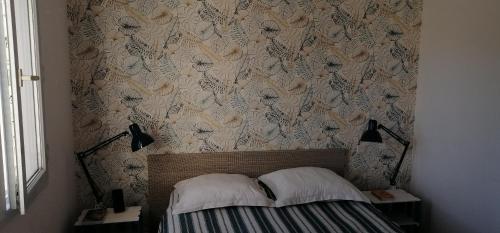 una camera da letto con un letto con carta da parati floreale di Bel appartement confortable et cosy en résidence avec piscine à 5 mn de la mer a Linguizzetta