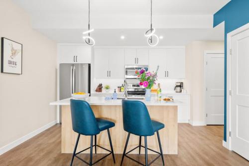 a kitchen with white cabinets and blue chairs at Stylish 2BR Golden Getaway with BBQ and Stunning Views in Golden