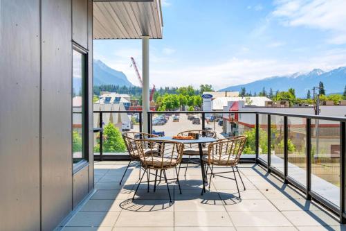 a patio with a table and chairs on a balcony at Stylish 2BR Golden Getaway with BBQ and Stunning Views in Golden