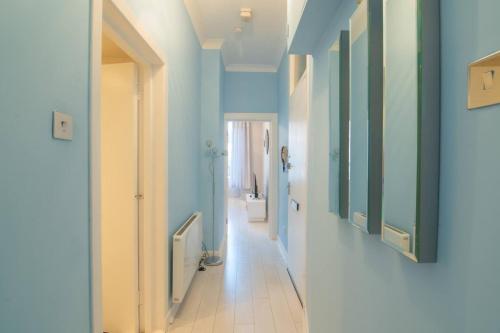 un couloir aux murs bleus et un couloir avec une salle de bains dans l'établissement Central Renfrew 1BR Apt, à Renfrew