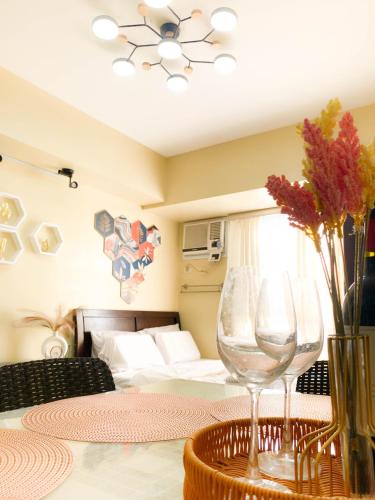 une chambre avec un lit et une table avec un verre à vin dans l'établissement Trendy Studio at Avida Riala It Park, à Mabolo