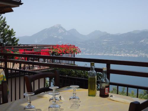 a table with wine bottles and glasses on a balcony at Albergo Alle Fasse in Brenzone sul Garda