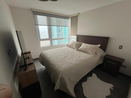 ein Schlafzimmer mit großem Bett und Fenster in der Unterkunft Departamento completo in Iquique