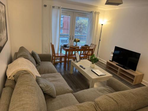 un salon avec un canapé et une table dans l'établissement Modern 2-Bed Near Braehead, à Renfrew