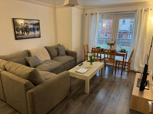 un salon avec un canapé et une table dans l'établissement Modern 2-Bed Near Braehead, à Renfrew