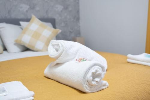 une pile de serviettes posée sur un lit dans l'établissement Stylish 2BR in Renfrew, à Renfrew