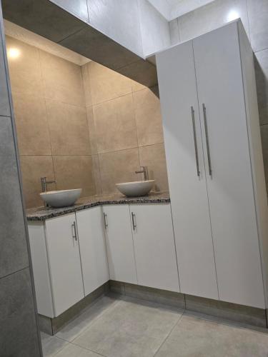 Apartment 33 في خليج ريتشاردز: حمام به دواليب بيضاء ومغسلتين