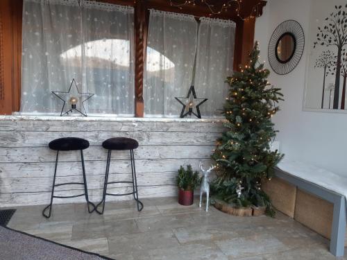 ein Zimmer mit einem Weihnachtsbaum und zwei Hockern in der Unterkunft Abis Ferienwohnung Salzkammergut in Strobl