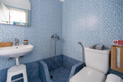 a blue tiled bathroom with a sink and a toilet at Cyclades Beach in Platis Yialos Sifnos