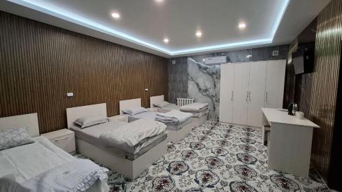 een kamer met drie bedden en een wastafel. bij Amiriy hostel in Bukhara