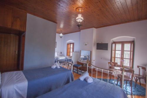 a bedroom with two beds and a table and a kitchen at Casa Calda in Sirako