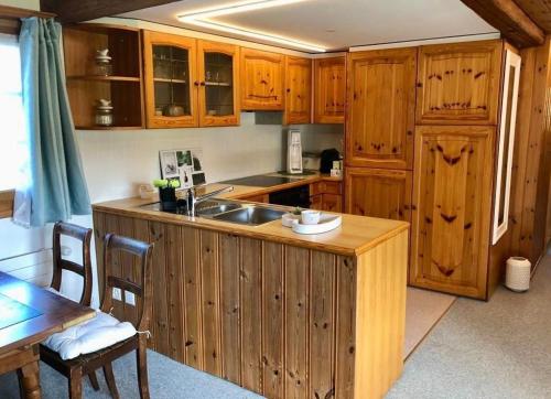une cuisine avec des armoires en bois, un évier et une table dans l'établissement Scheftenau, à Kappel