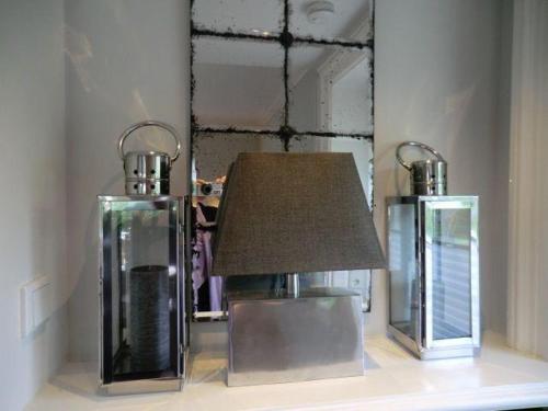 une lampe assise sur une table devant un miroir dans l'établissement Gartensuite-Kamin-Sauna-Pool-Garten, à Kampen