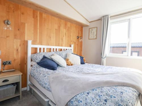 a bedroom with a bed and a window at Fairways 4 in Liskeard