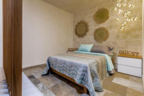 une chambre avec un lit et un mur avec un lustre dans l'établissement Cipressi Lofts Val'Quirico, à Santeagueda
