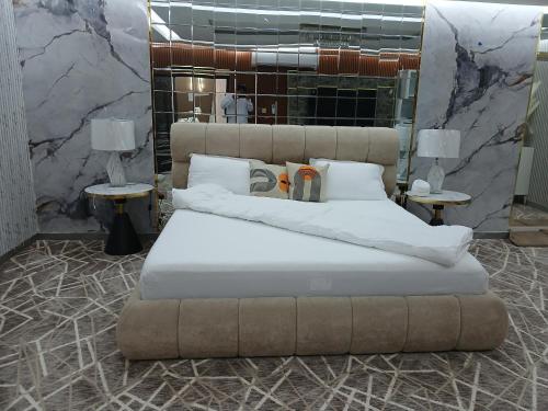 a bedroom with a large bed with white sheets and pillows at Mountain Park Rest in Ḑab‘ah