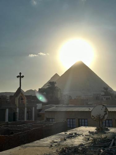 una vista di una piramide con il sole sullo sfondo di Osiris pyramids view inn a Il Cairo