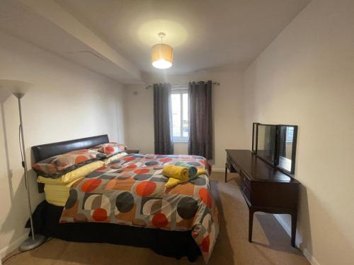 a bedroom with a bed and a desk and a television at Executive 1 Bed Lovely Apartment in Aberdeen