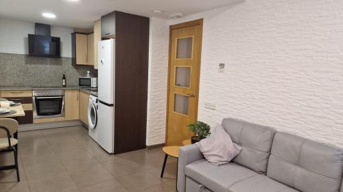 un soggiorno con divano e cucina di Lo Pateret a Corbera