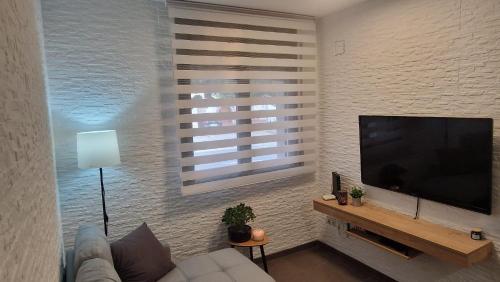 un soggiorno con una grande TV a schermo piatto di Lo Pateret a Corbera