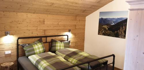a bedroom with a bed with green and white pillows at Chalet Weitsee in Reit im Winkl