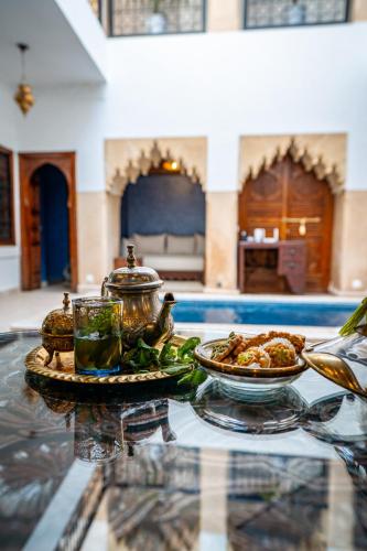 a glass table with a plate of food on it at Riad Serendip in Marrakesh