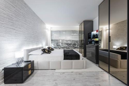 a bedroom with a white bed and a brick wall at Gramsci Prestige Apartment in Bologna