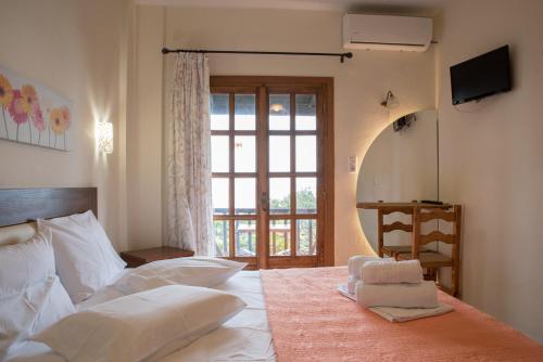 a bedroom with a bed with a large window at To Mpalkoni in Chorefto