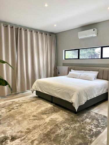 une chambre avec un lit et une grande fenêtre dans l'établissement Wabi Sabi, à Johannesbourg