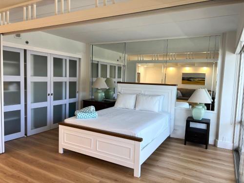 1 dormitorio con 1 cama blanca grande y armarios de cristal en Ilikai Tower 1936 condo, en Honolulu