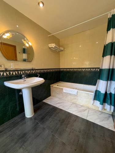 ein Badezimmer mit Waschbecken und Badewanne in der Unterkunft Hostal Tarrés in Anglés