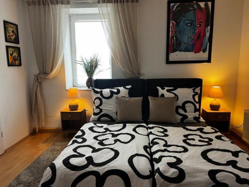 a bedroom with a bed with a black and white comforter at Apartment im Grünen -Garden in Chemnitz