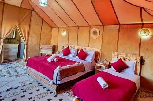 1 dormitorio con 2 camas en una tienda de campaña en Merzouga Best Luxury Camp, en Merzouga