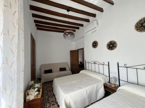 ein Schlafzimmer mit zwei Betten und einer Couch in der Unterkunft Alojamientos El Carmen in Ugíjar