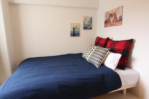 una camera da letto con un letto blu con due cuscini di Pine Hills Minoshima - Vacation STAY 12181 a Sumiyoshi