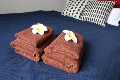 due asciugamani con fiori sopra un letto di Pine Hills Minoshima - Vacation STAY 12181 a Sumiyoshi
