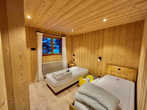 a room with a bed in a wooden room at Résidences Delavay La Cordée in Les Gets