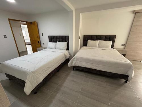 two beds sitting next to each other in a bedroom at Yellow House in Manizales