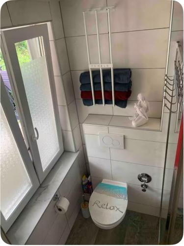 a bathroom with a toilet and a mirror and towels at Klimatisierte Ferienwohnung in Balingen