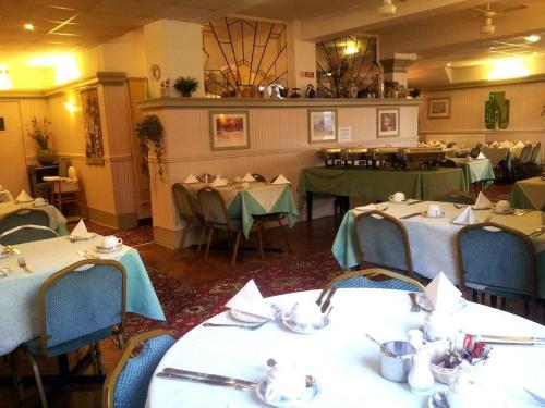 a dining room with tables and chairs in a restaurant at The New Osterley Hotel in Blackpool
