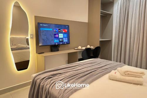 ein Krankenhauszimmer mit einem Bett und einem Flachbildfernseher in der Unterkunft Solaz Smart Living - LikeHome Hospedagens in Tambaú