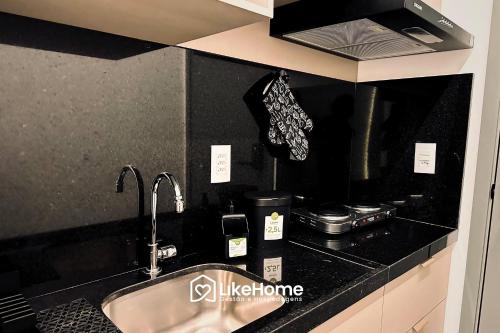 eine Küchentheke mit einer Spüle und einem Herd in der Unterkunft Solaz Smart Living - LikeHome Hospedagens in Tambaú