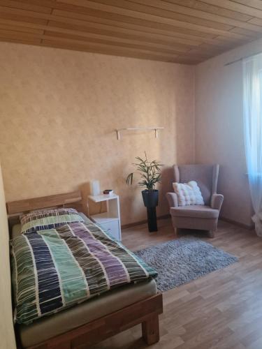a bedroom with a bed and a chair at Ferienwohnung in Flörsheim