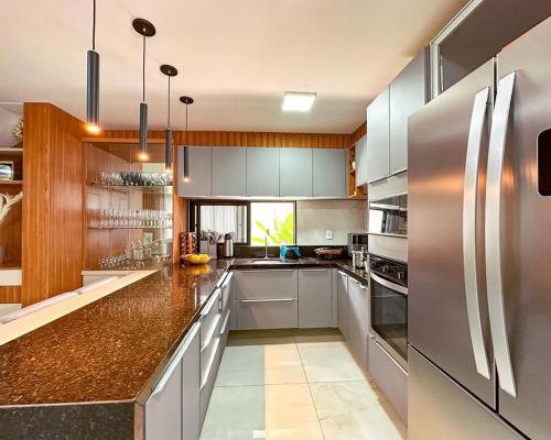 eine Küche mit weißen Schränken und Geräten aus Edelstahl in der Unterkunft Casa Moderna & Conforto in Eusébio