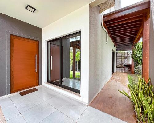 eine Außenansicht eines Hauses mit einer Holztür in der Unterkunft Casa Moderna & Conforto in Eusébio