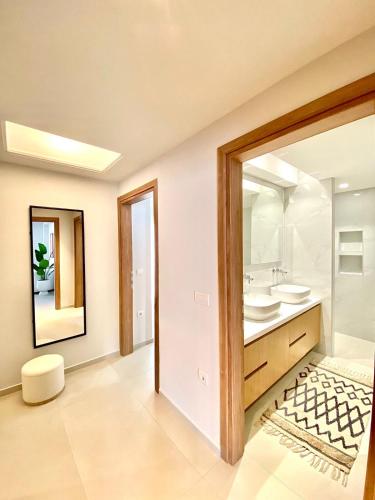 une salle de bain avec deux lavabos et un miroir dans l'établissement Aurelia Residence, à Ampavris