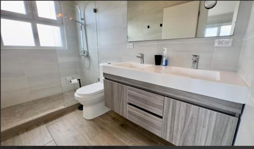 Un baño con lavabo e inodoro en The Executive Suite, en Puerto España