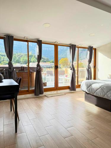 a bedroom with a bed and a desk and windows at Apartamento en Montserrat- Montserrat Paradise Apartament in Monistrol